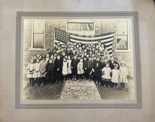 Students of Rockwood Public School gathered with an American flag, December 15, 1915